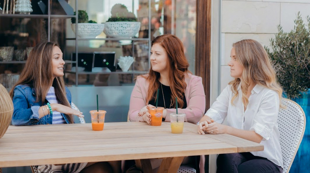 Consultant Alyson Caffrey of Operations Agency sitting with two other people drinking juice.