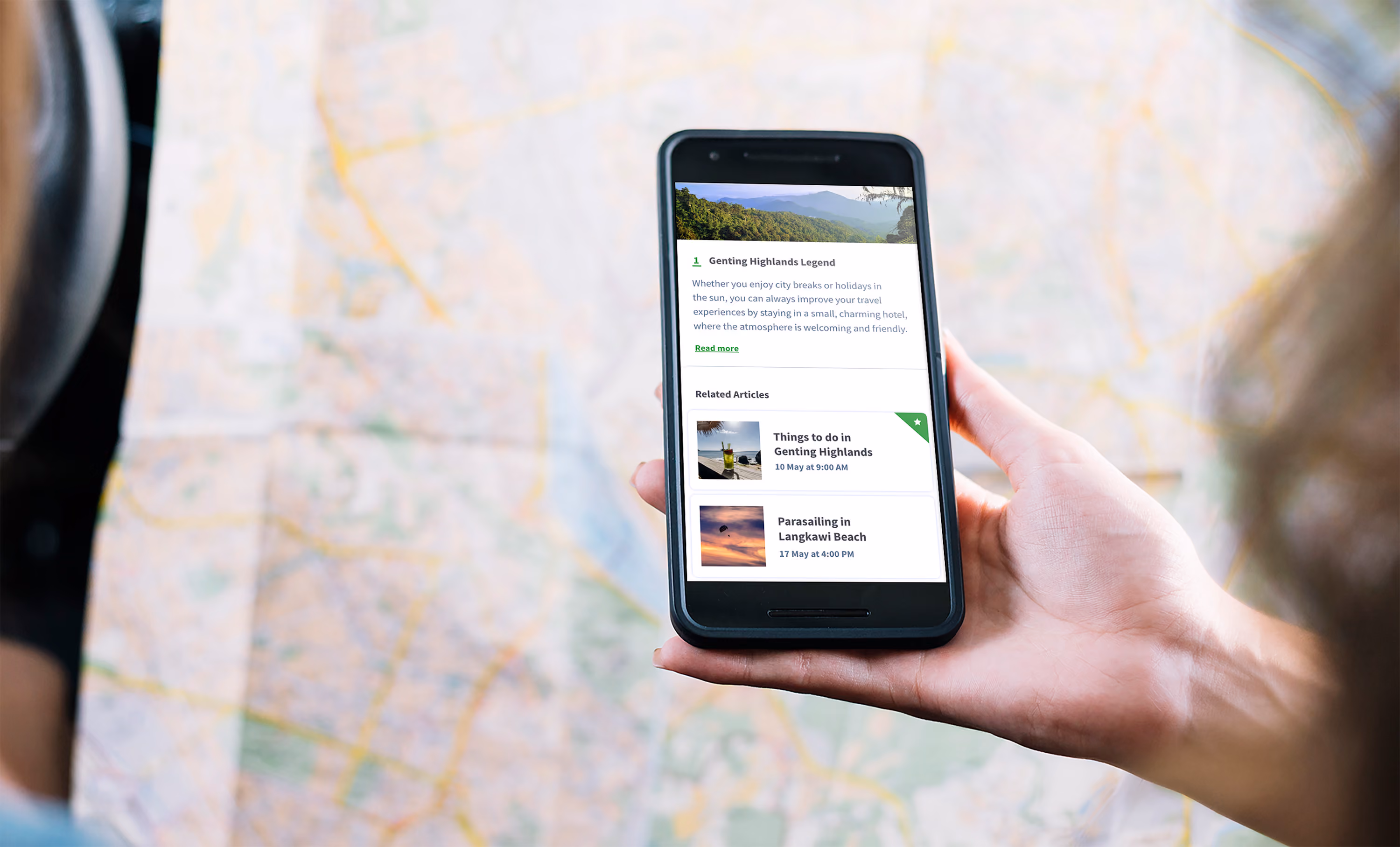 Woman holding a mobile phone displaying a destination article page.