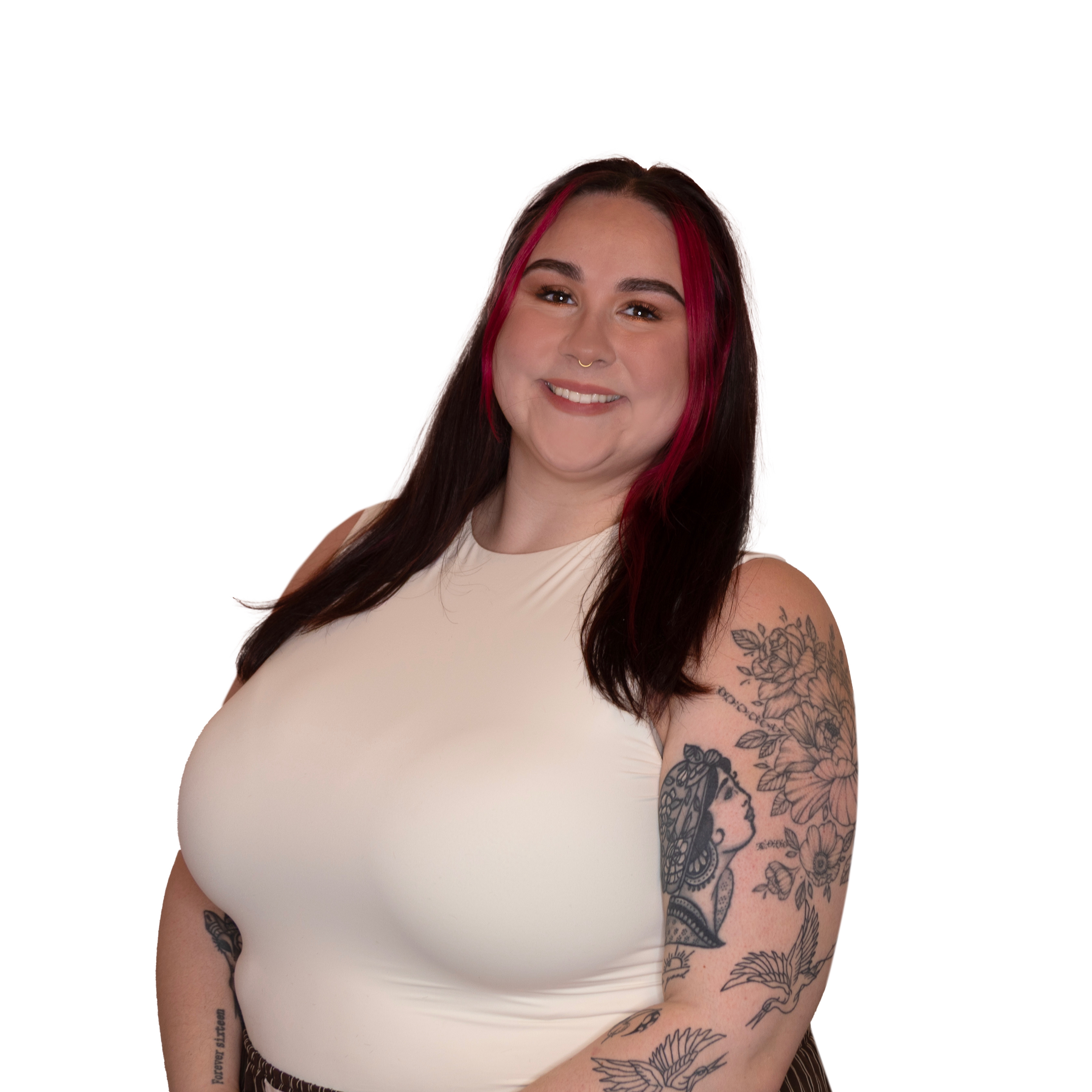 Smiling woman with long dark hair and red highlights wearing a white sleeveless top, showing tattoos on her arms.