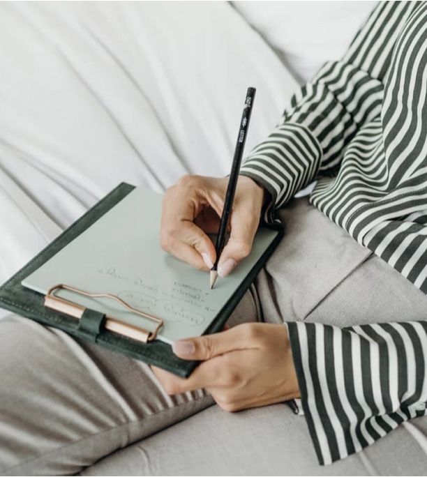Jamie Maclennan_Our Partners page - Image of a person writing notes on a clipboard