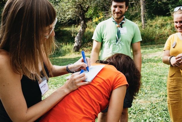dívka v přírodě píšící si poznámky