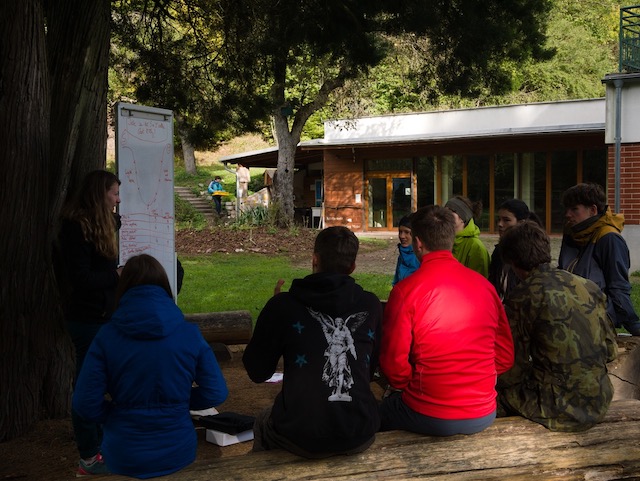 Dívka v přírodě píšící si poznámky