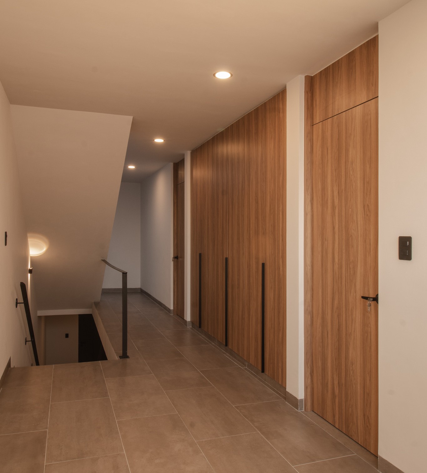 Pasillo en casa moderna con clósets de madera y escaleras