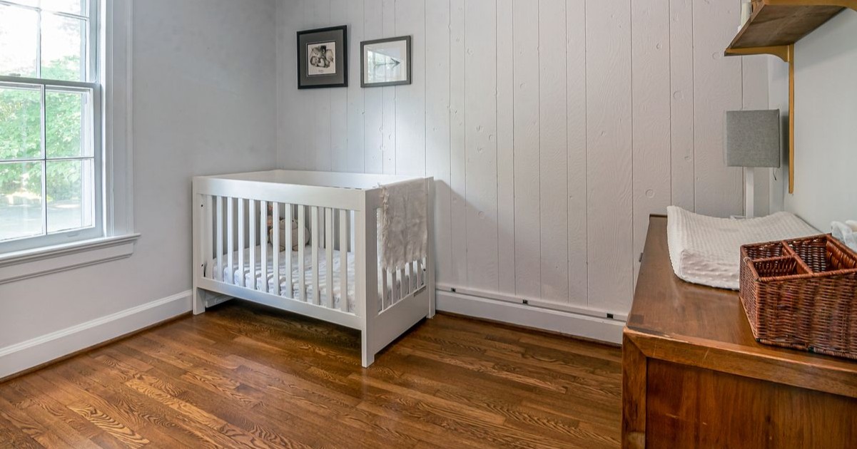 Habitacion para bebe paredes blancas piso de madera