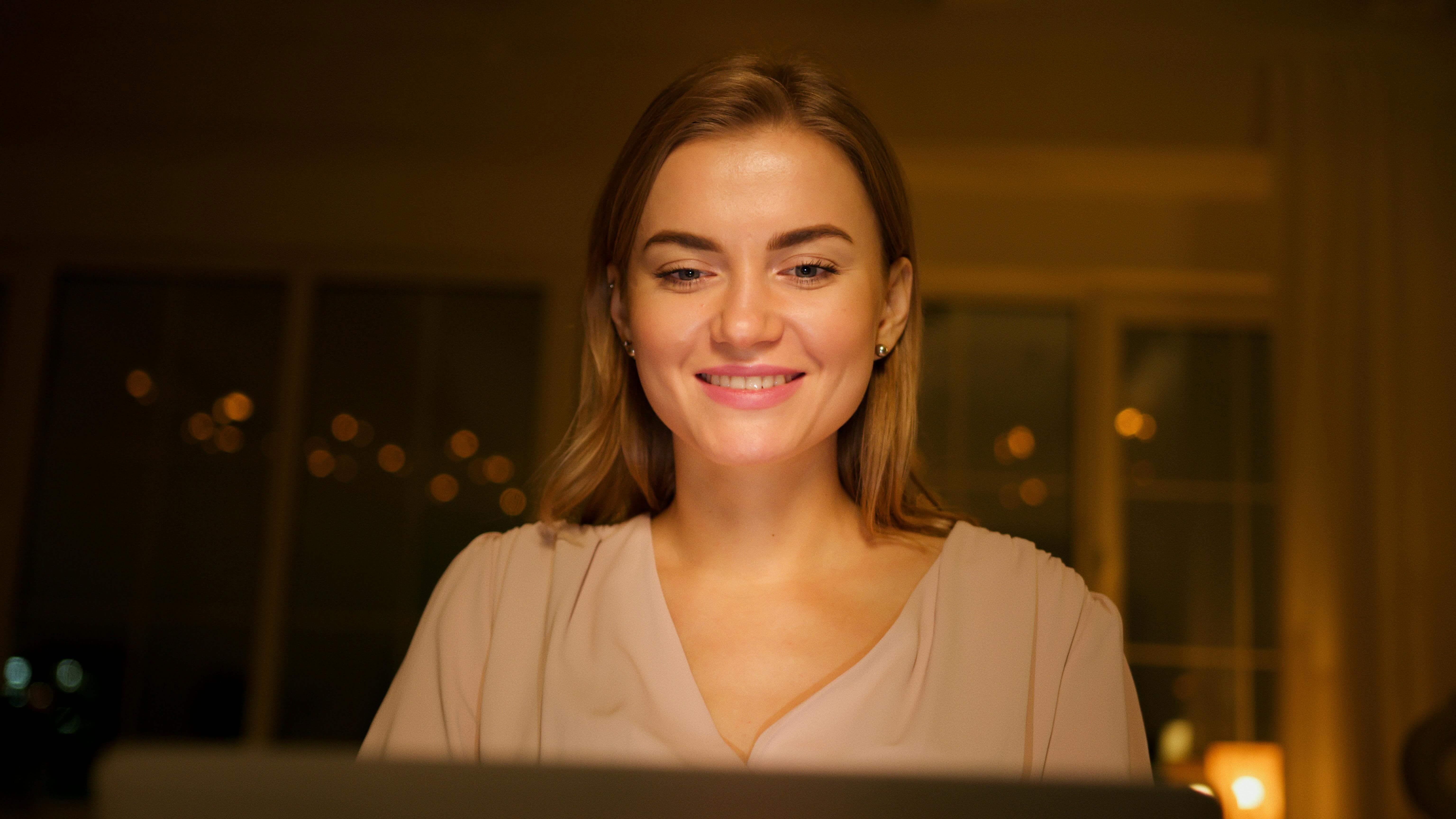 Woman smiling during online therapy session from home