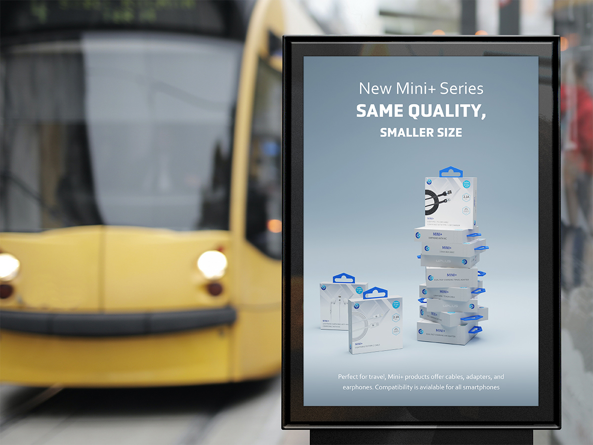 An outdoor sign of Mini+ products with a yellow train in the background.