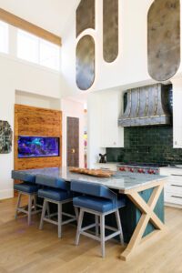 The open kitchen mixes metals with wood, stone and curated art.