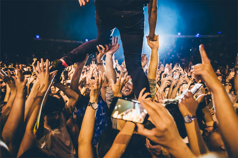 Público rodeando a un artista desde el escenario de Noches del botánico