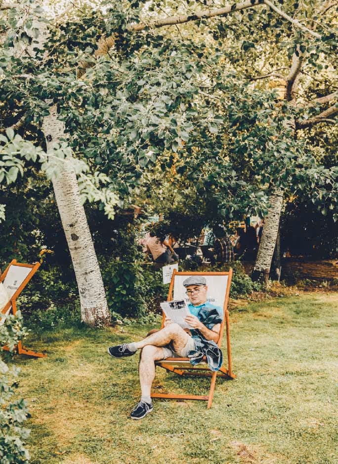 Persona sentada en amaca en la zona de descanso del jardín botánico durante Noches del Botánico.