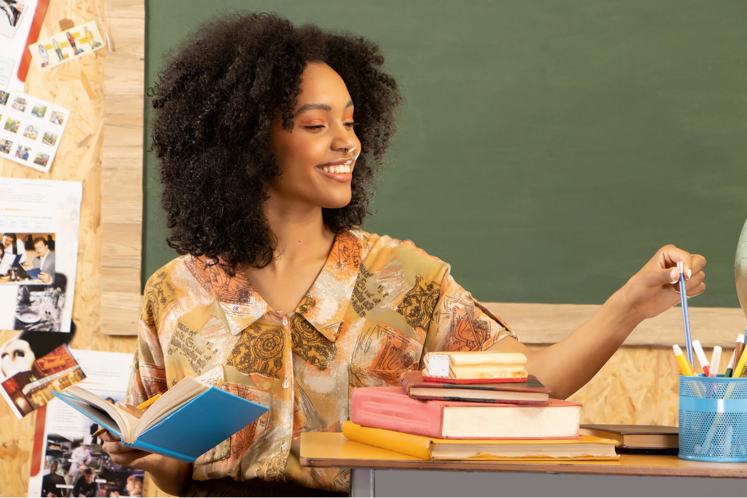 A woman with a smile on her face is holding a book. - New Leaders Images