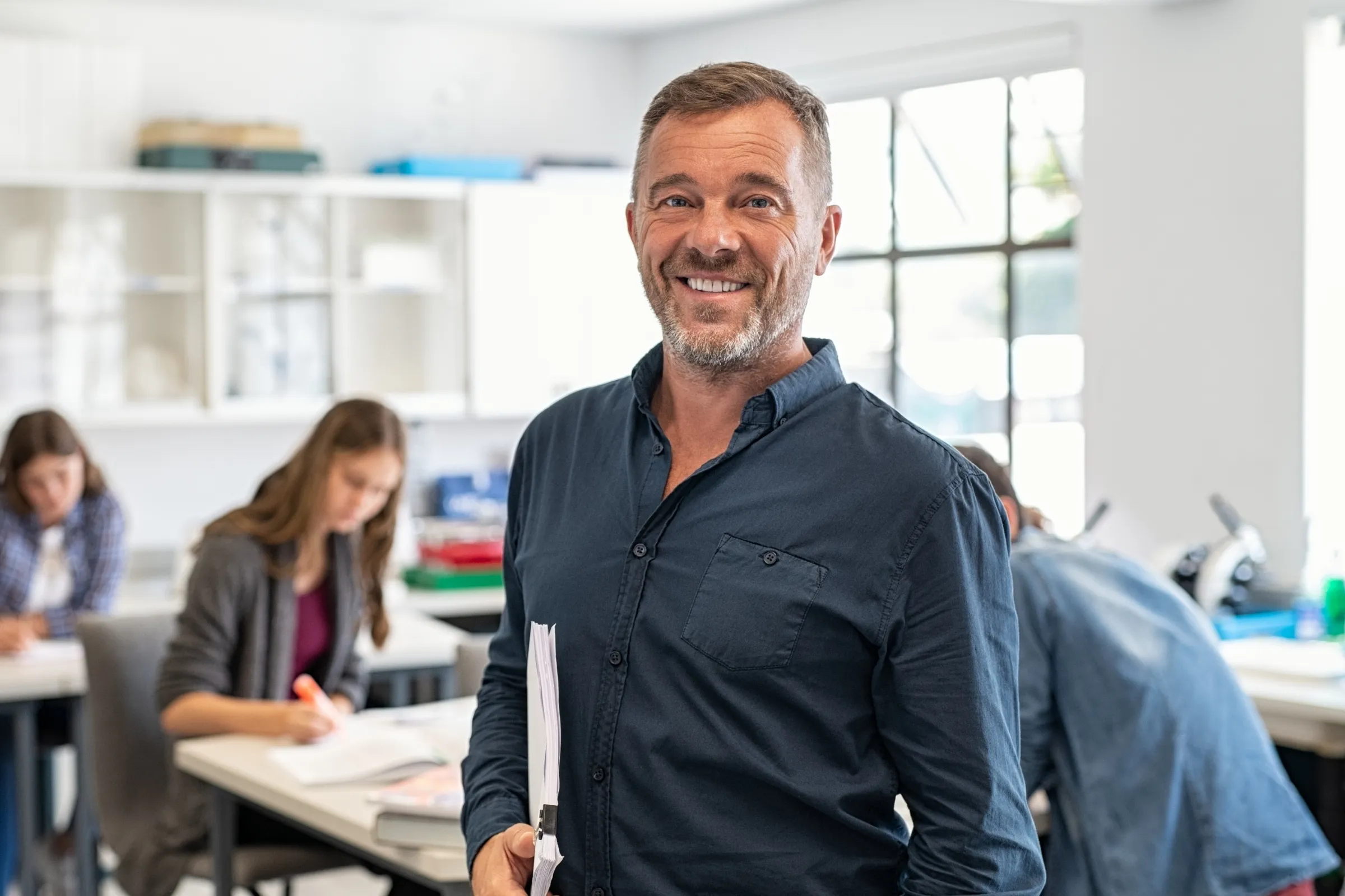 A man in a blue shirt smiles at the camera. - New Leaders Images