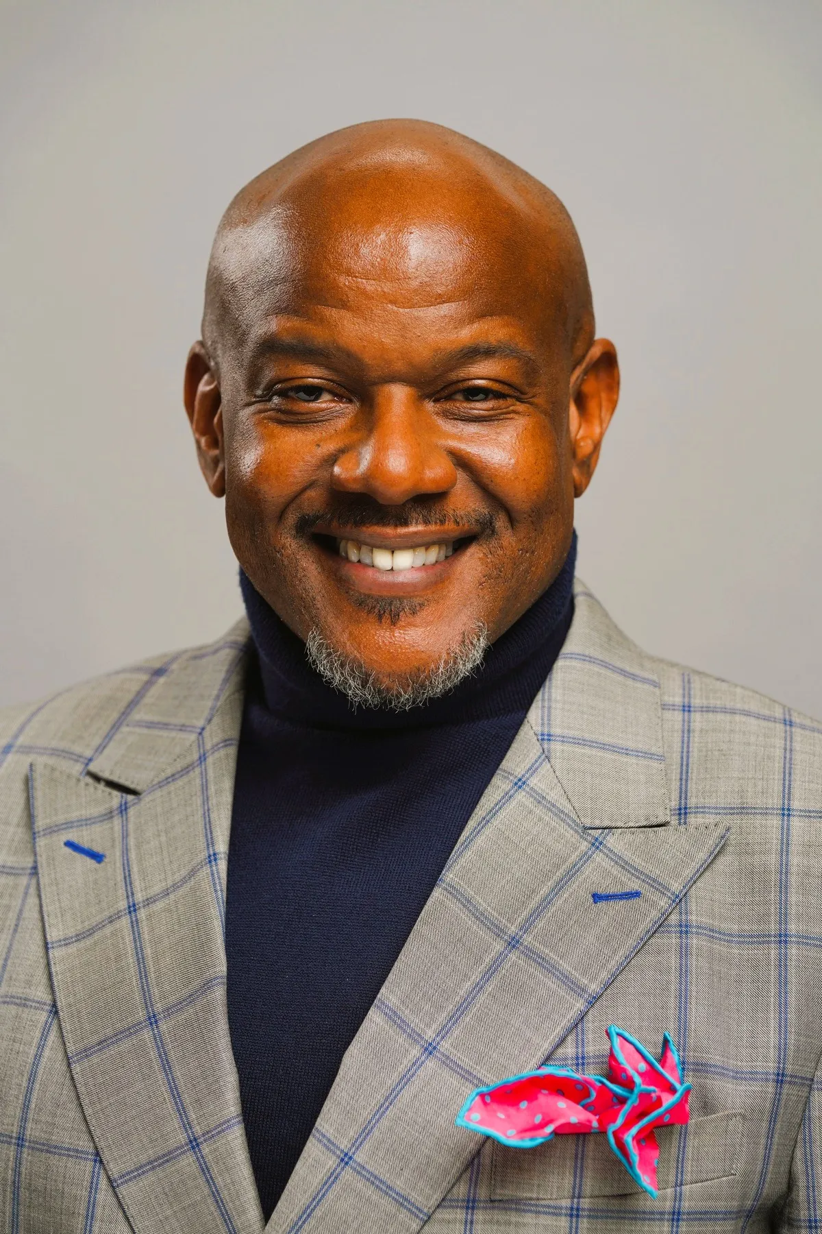 A man wearing a blue and white jacket smiles for the camera. - New Leaders Images