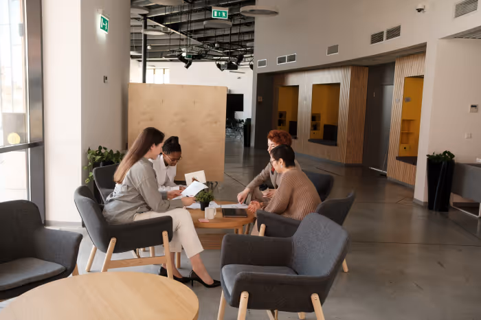 Group of young workers discussing at a desk.