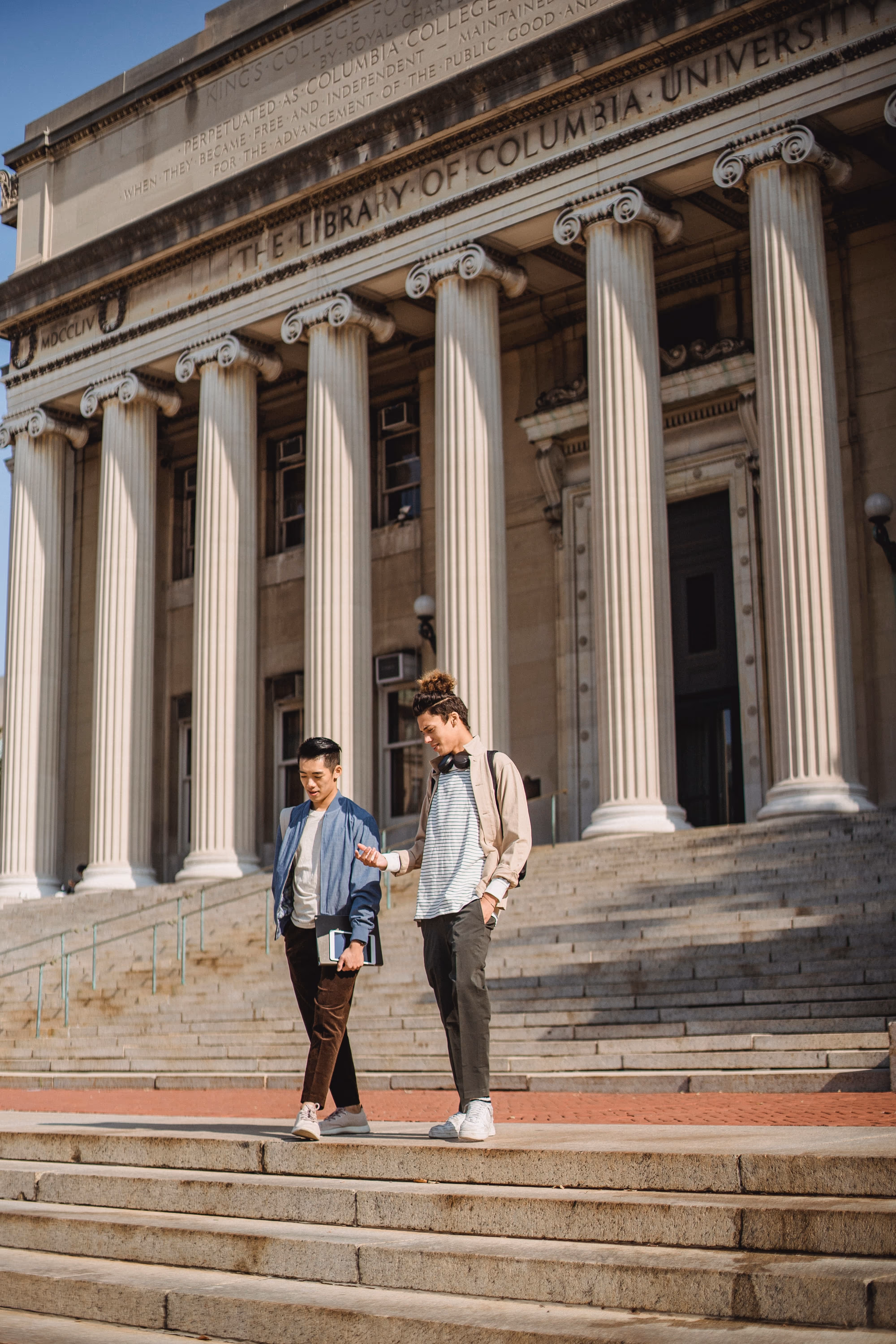 Two college students walking down a flight of stairs