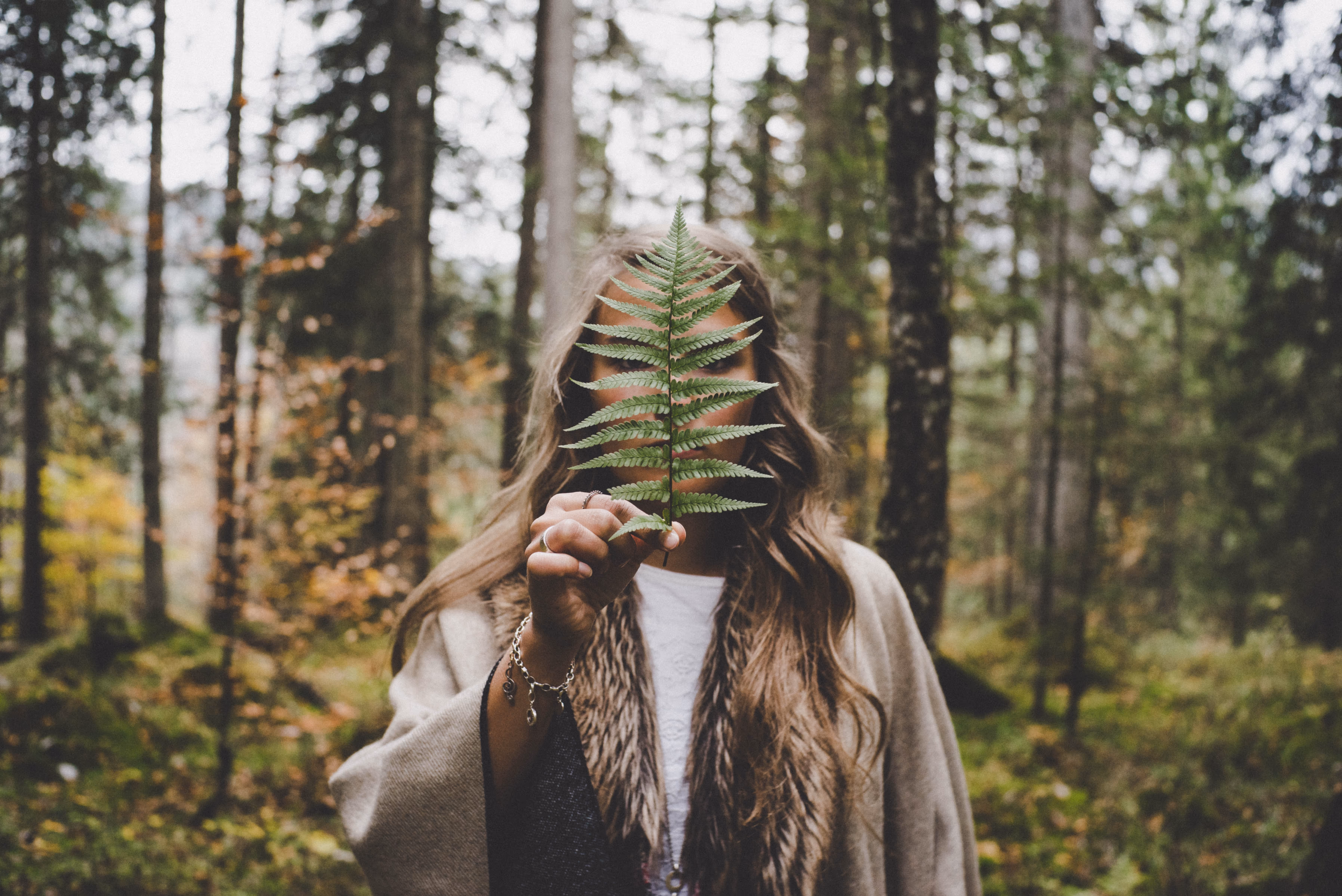 Woman holding a leaf in the woods