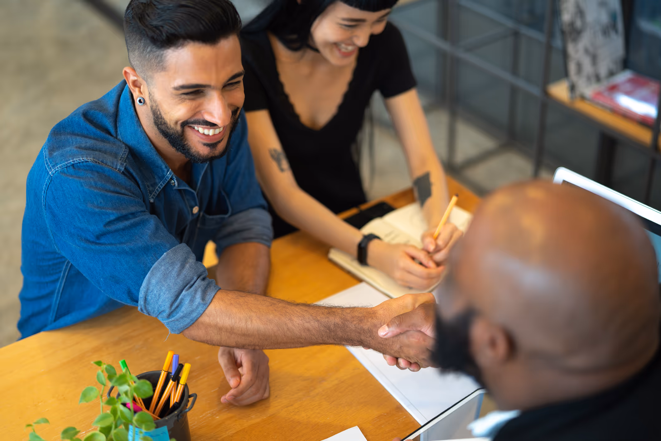 two insurance customers shaking hands of insurance sales person