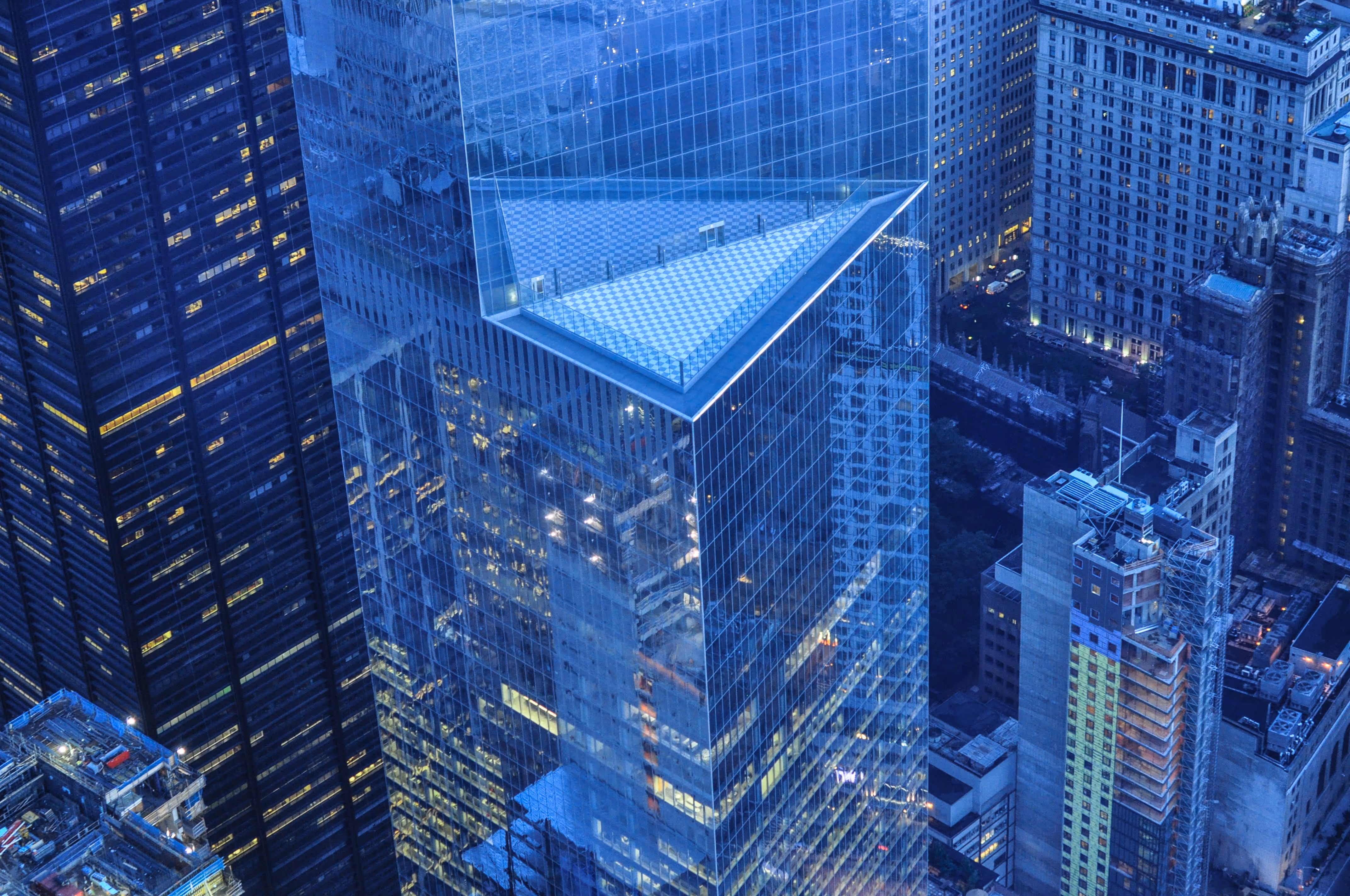 A picture of tall, glass skyscraper city buildings. they look dark blue.