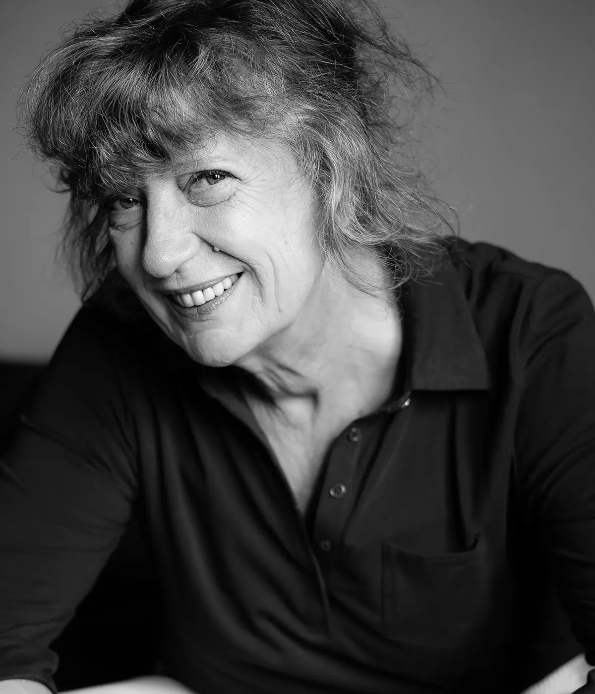 Portrait en noir et blanc d'Élisabeth Galton, coach et fondatrice de GE Consultants, souriante en chemise noire.