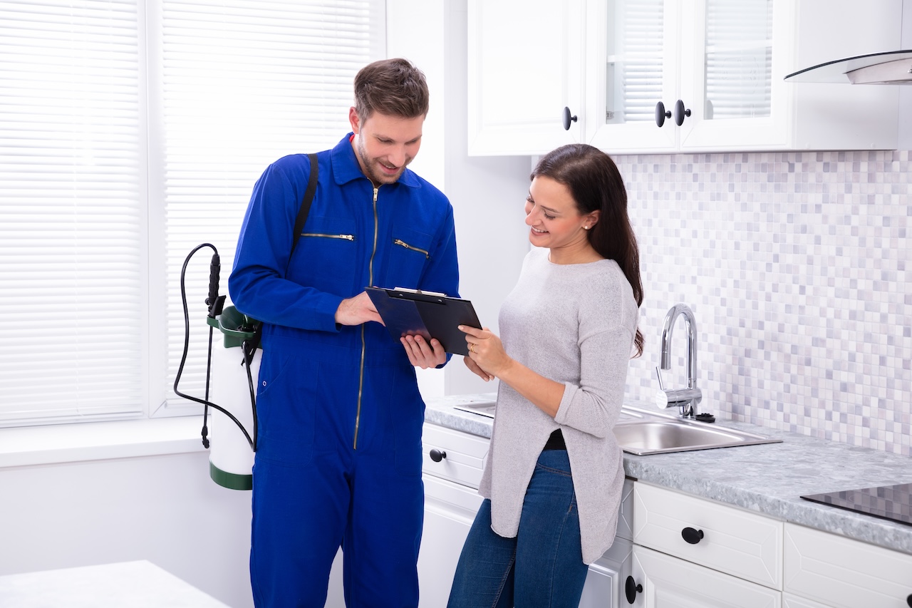 Pest control worker presenting an invoice to a female customer, highlighting clear communication and transparent billing practices.