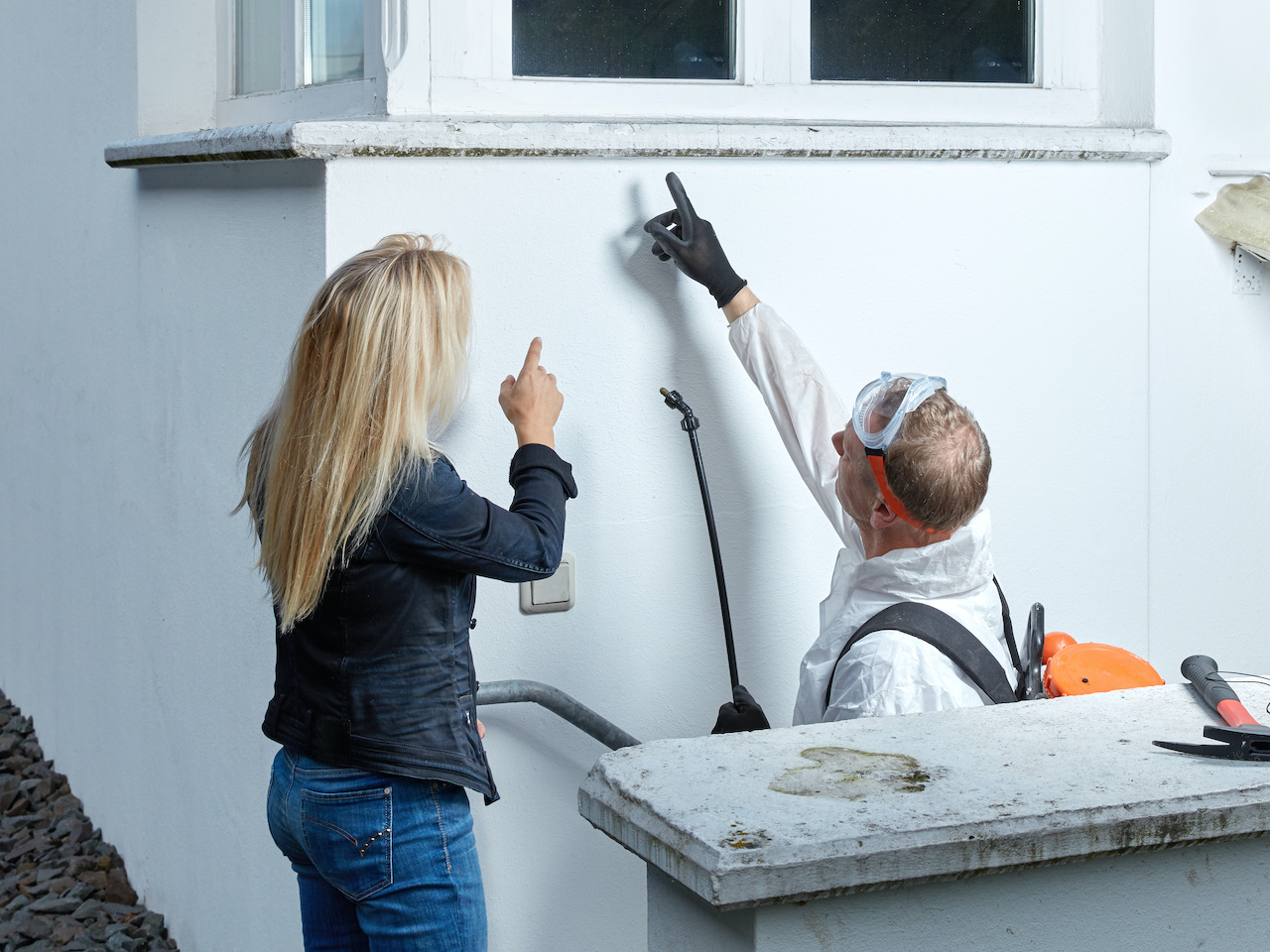 Pest control technician explains something to a customer.