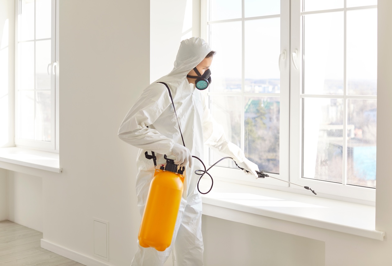 Pest control technician performing a treatment at a customer location during a scheduled service