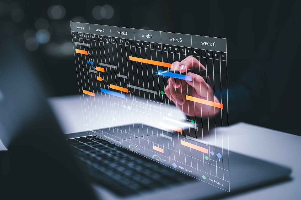 Office team reviewing scheduling interface on a laptop, representing organized task management, efficient routing, and connected pest control business software.