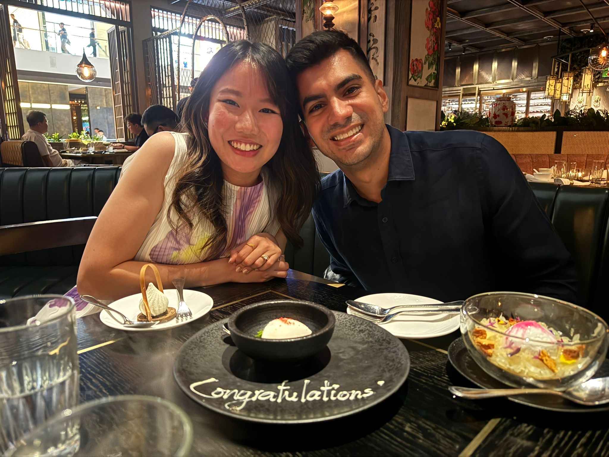My husband and I with a dessert that reads "Congratulations" 