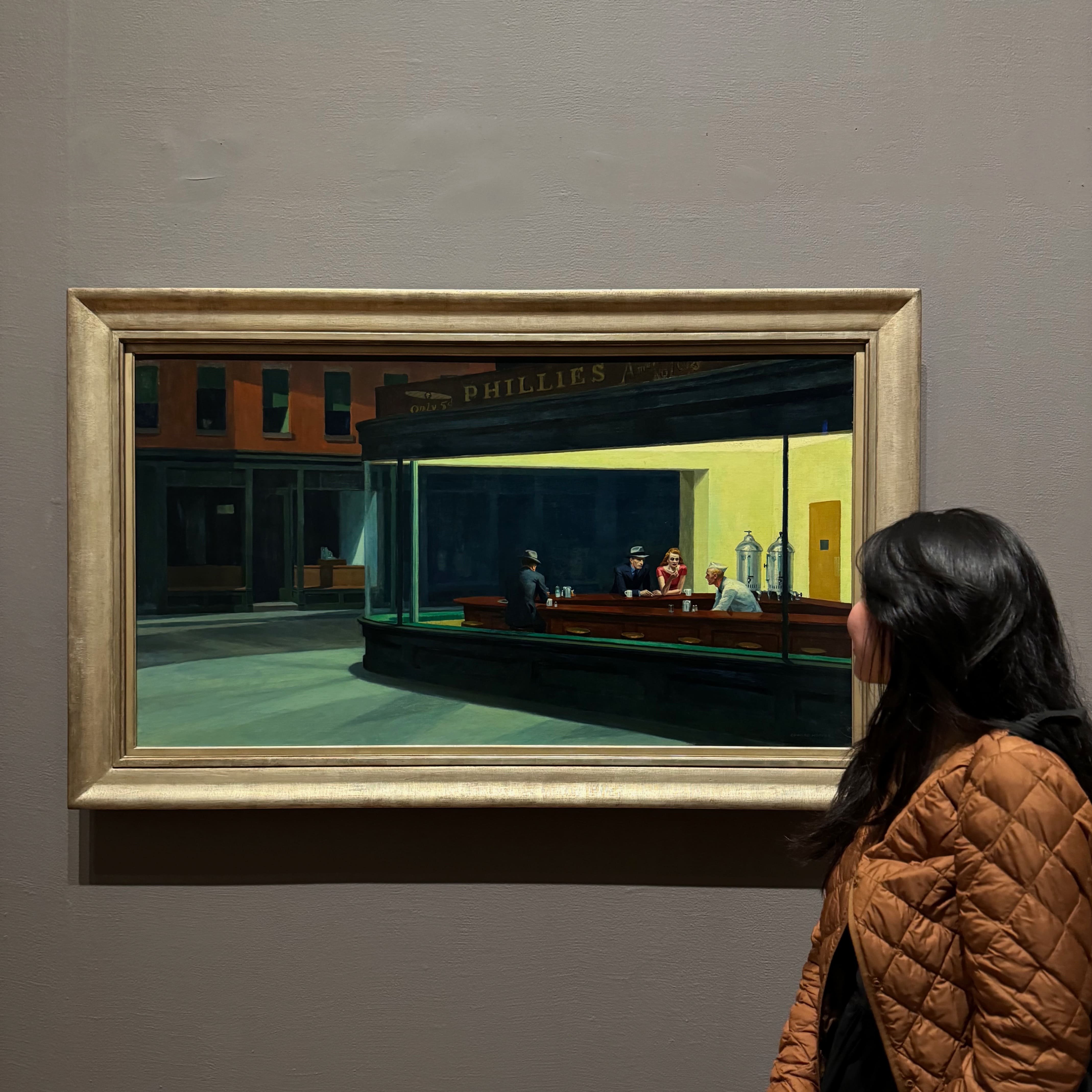 Myself standing in front of the oil painting of a late night diner by Edward Hopper