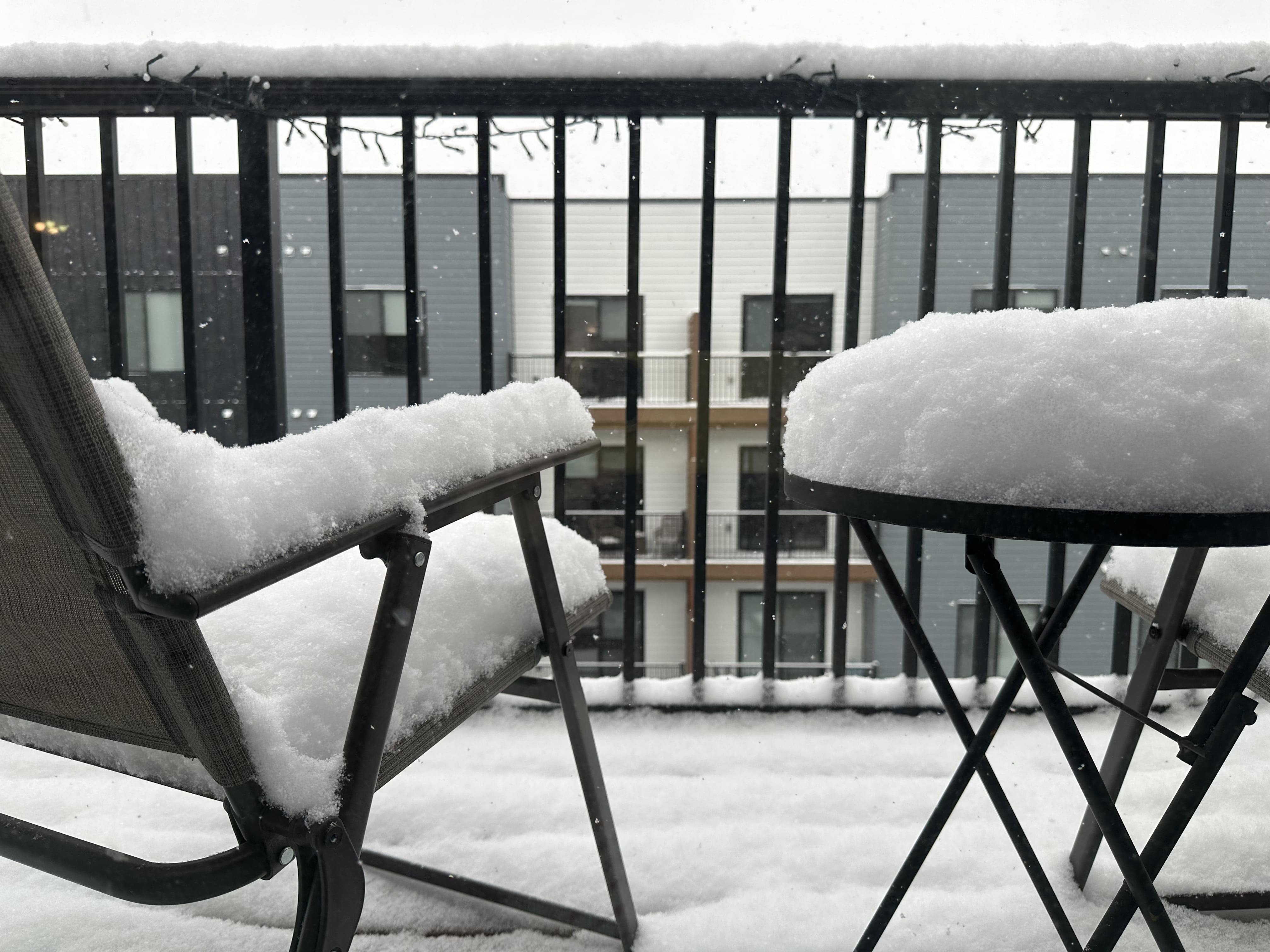 Snow on top of outdoor furniture in my Omaha apartment