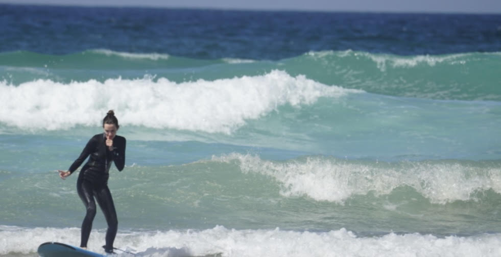 Woman surfing wave at Watergate Bay