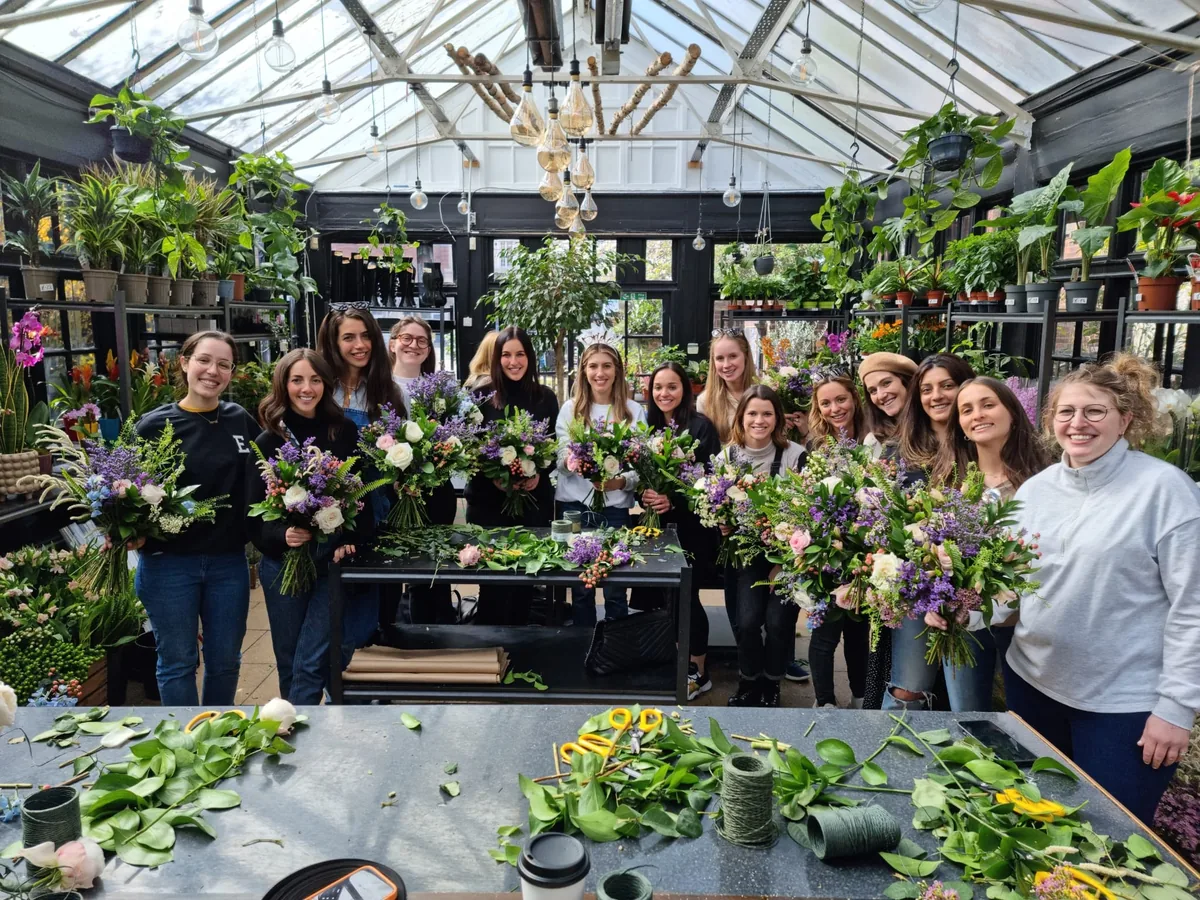 Office team holding bouquets at a flower arranging workshop