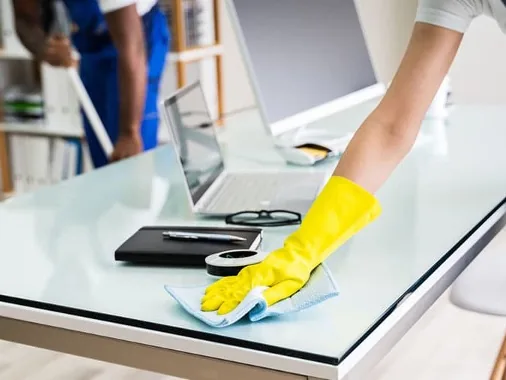 Cleaner wiping down an office desk