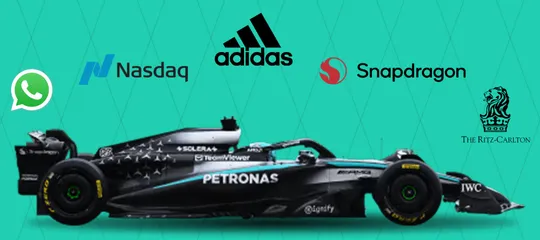 Mercedes F1 car with WhatsApp, Nasdaq, adidas, Snapdragon, and Ritz-Carlton logos above it