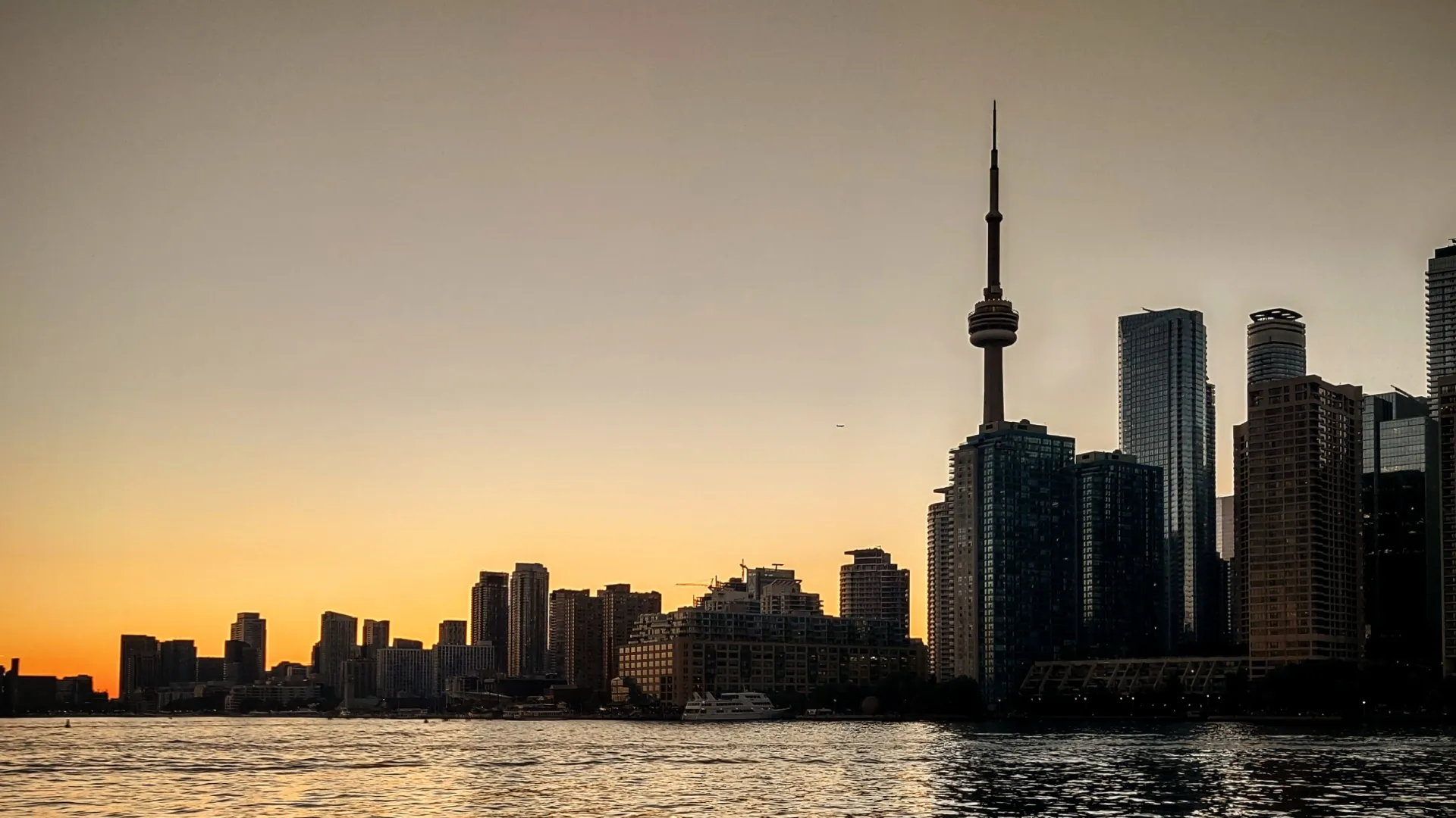 A sunset-light skyline of Toronto, Ontario, featuring the CN Tower