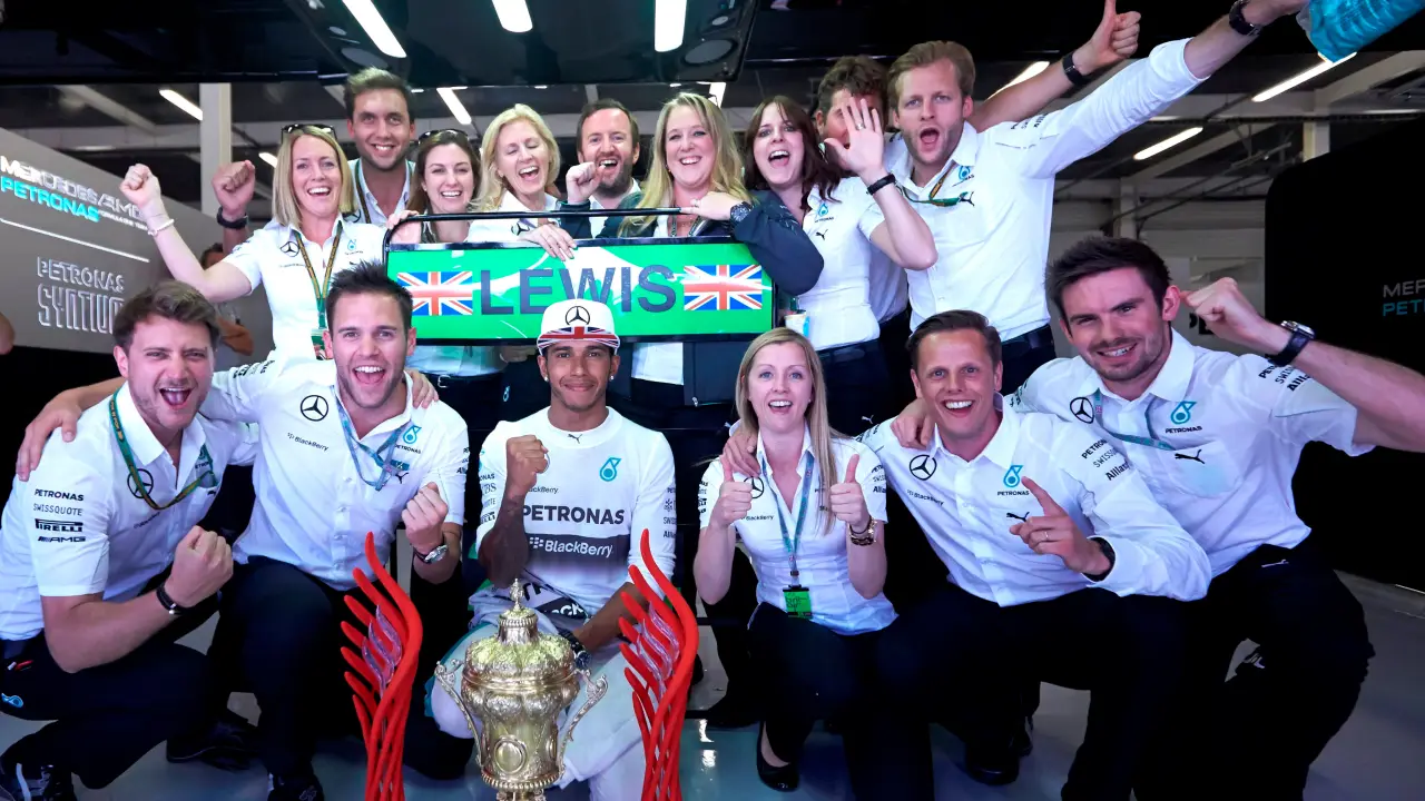 Ben Cowley celebrating with Lewis Hamilton and the Mercedes team