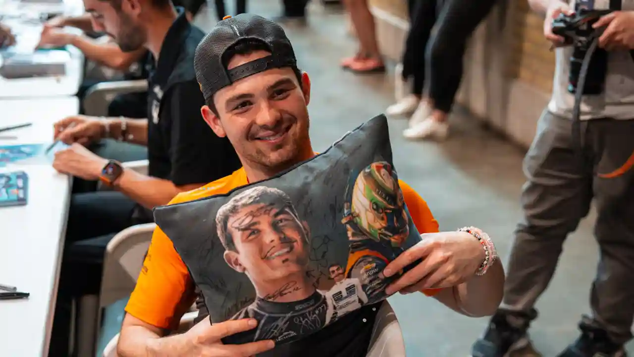 Pato O'Ward with a fan gift at an autograph session
