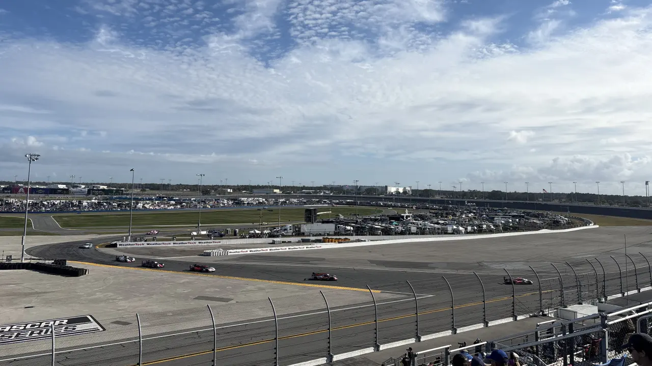 Cars racing by at Turn 6 as seen from the Main Grandstand