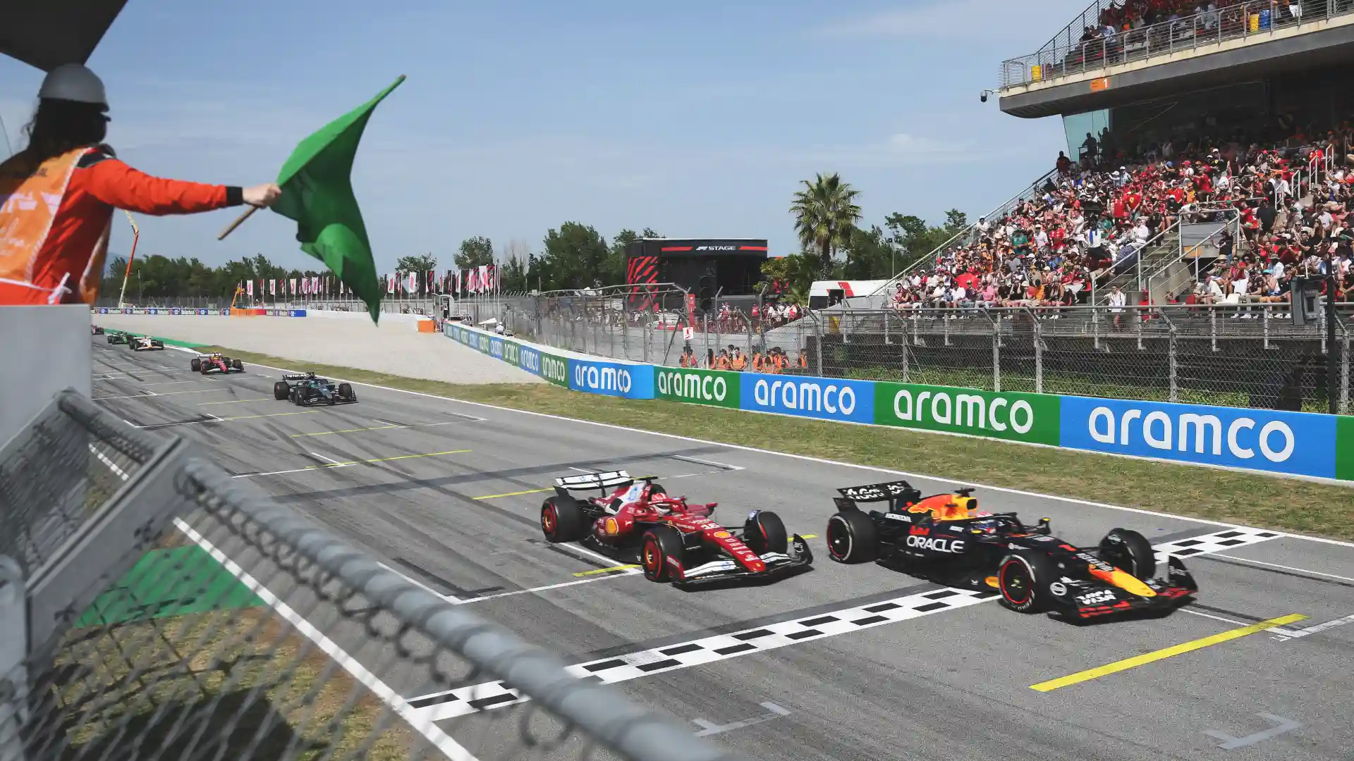 Red Bul and Ferrari F1 cars cross finish line at Spanish GP in Barcelona