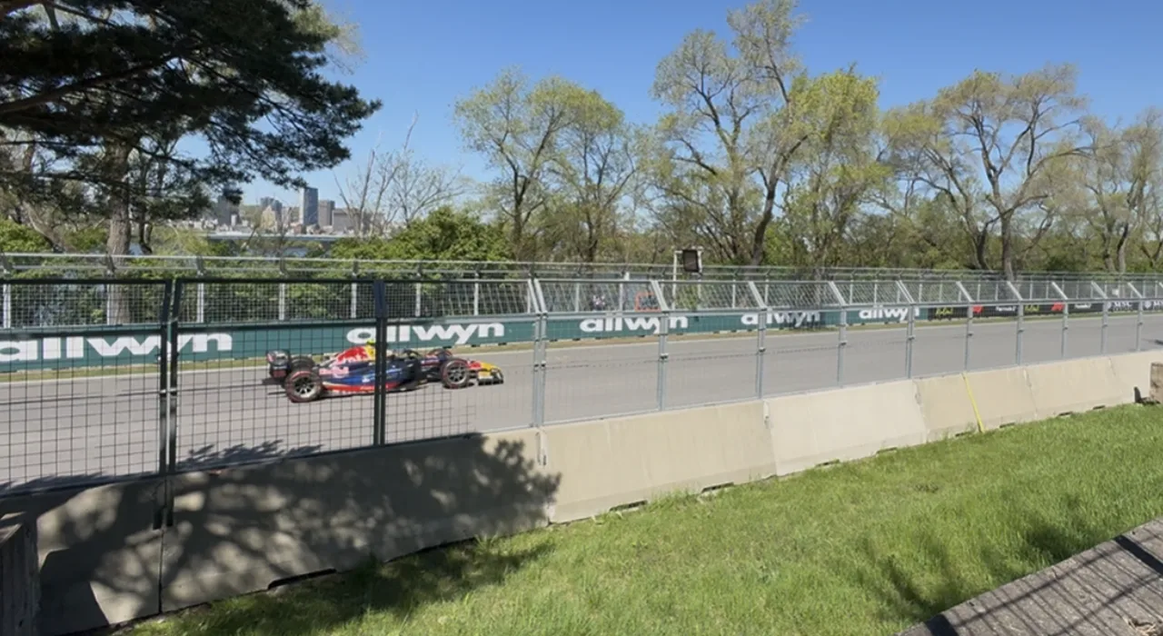 A Formula 2 car driving past the viewing pocket after Turn 6