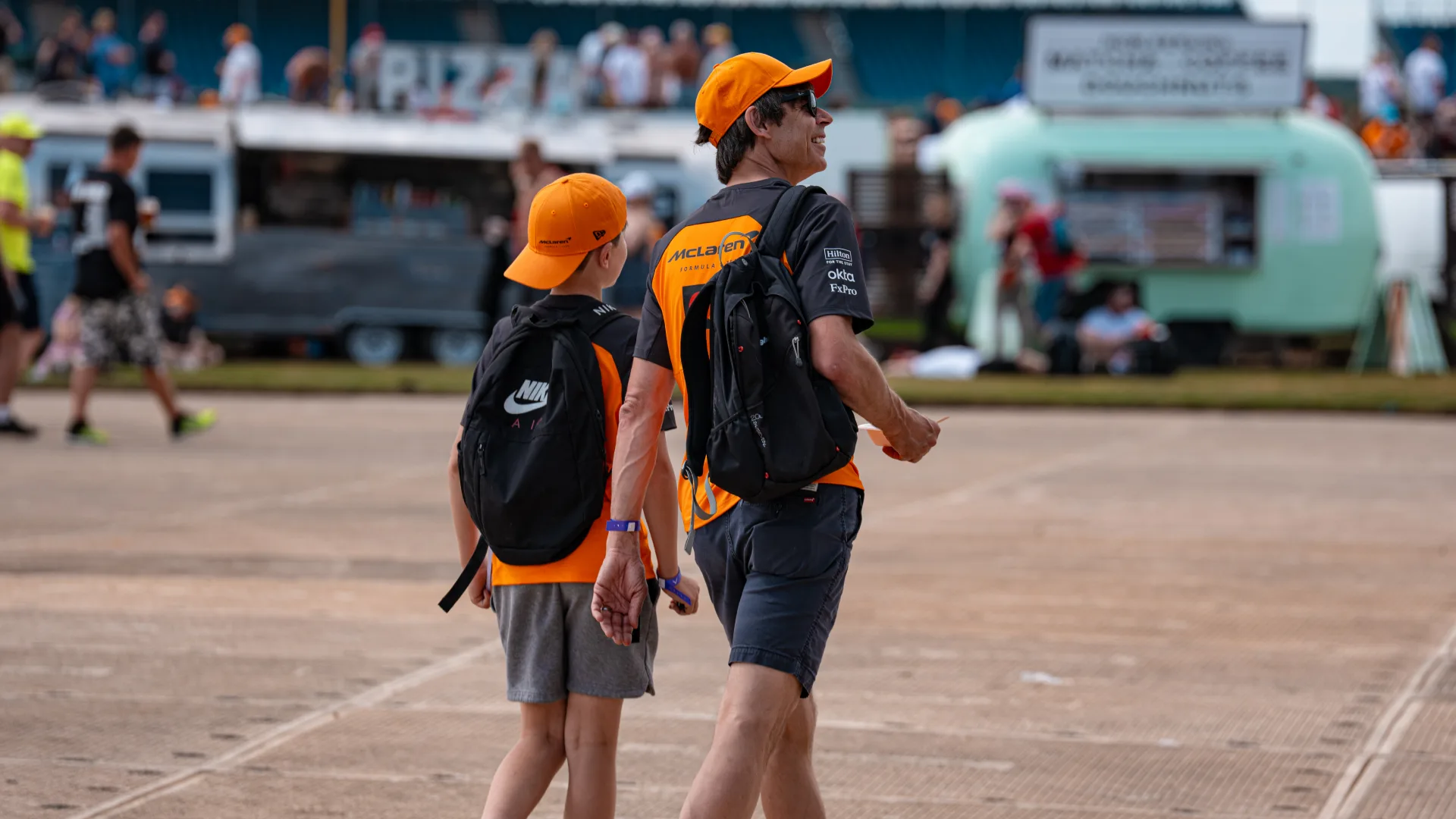 Two Formula 1 fans with their backpacks