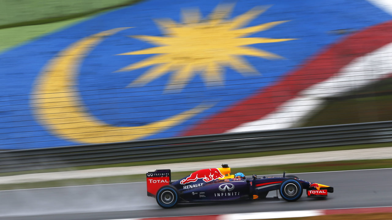 Sebastian Vettel races in front of the Malaysian flag at the 2014 Malaysian Grand Prix. (Photo: Andrew Hone, Getty Images/Red Bull Content Pool)