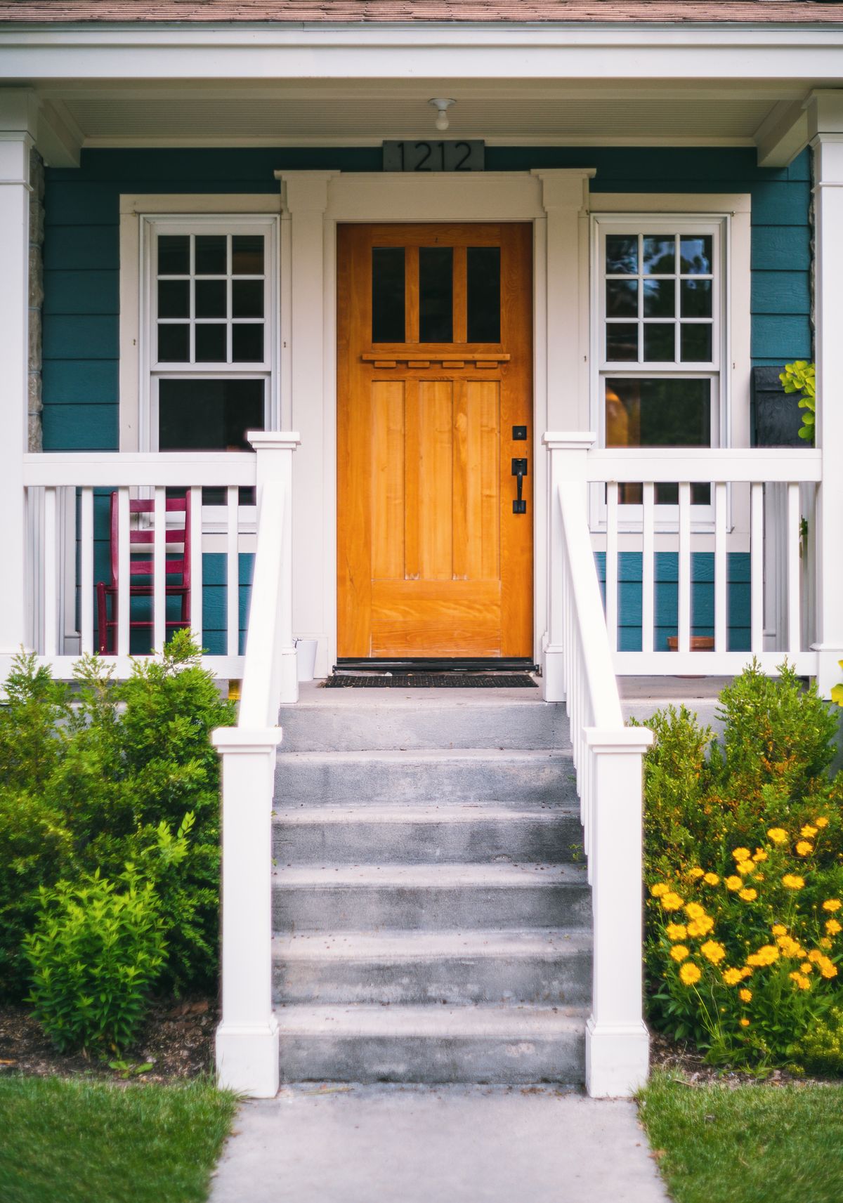 Inviting front porch with a freshly installed wooden entry door
