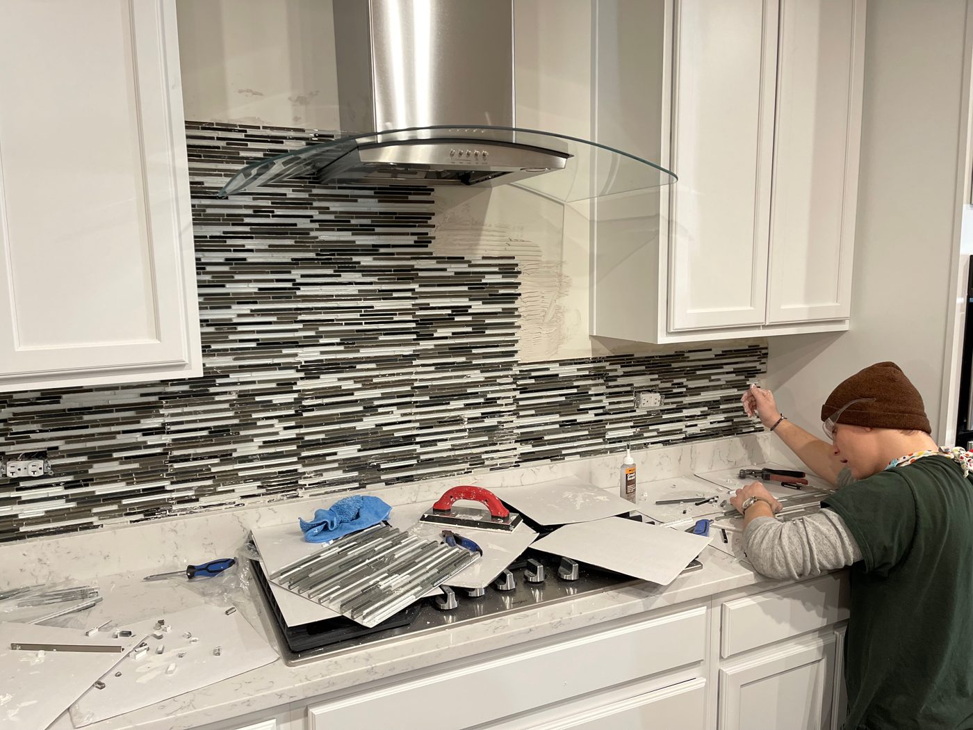 Crew member installing a mosaic kitchen backsplash
