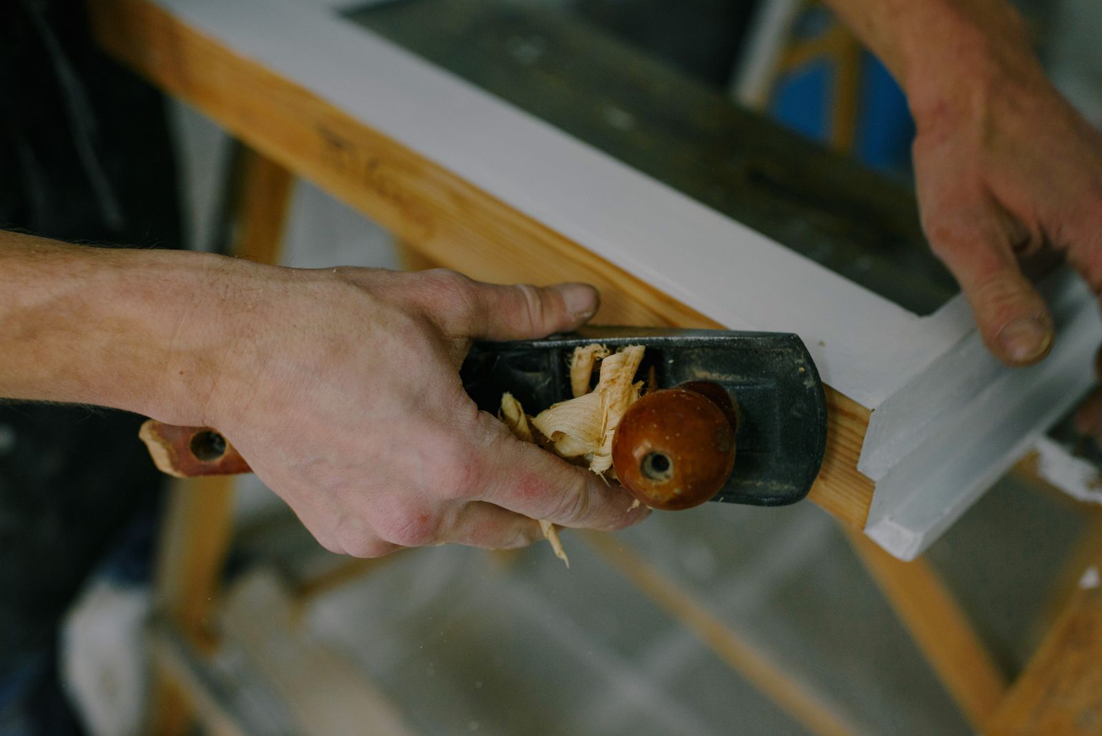 Carpenter working on wood trim with hand tools