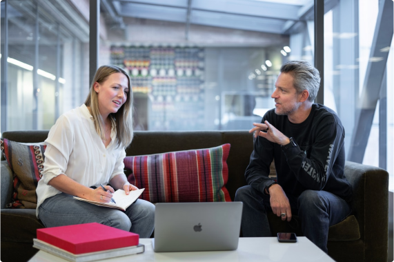Två personer samtalar över ett konferensbord