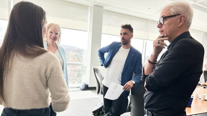 Petit groupe en discussion dans une salle de réunion vitrée durant un C.A. de la Fondation du CHUS