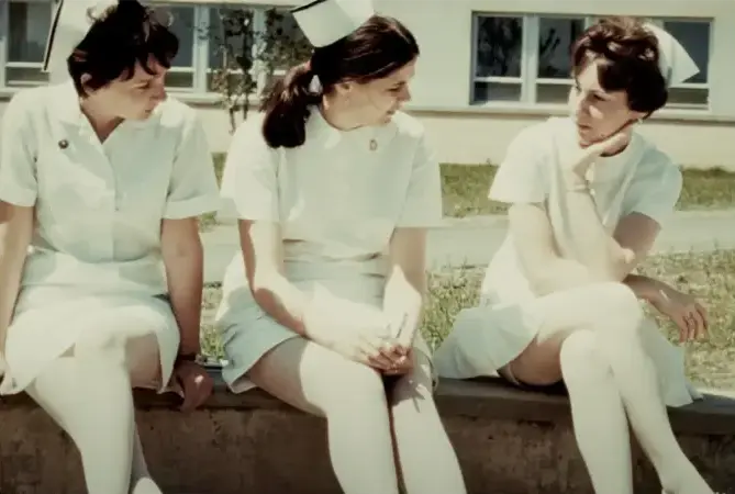 Trois infirmières en uniforme blanc discutant ensemble à l’extérieur de l’hôpital.