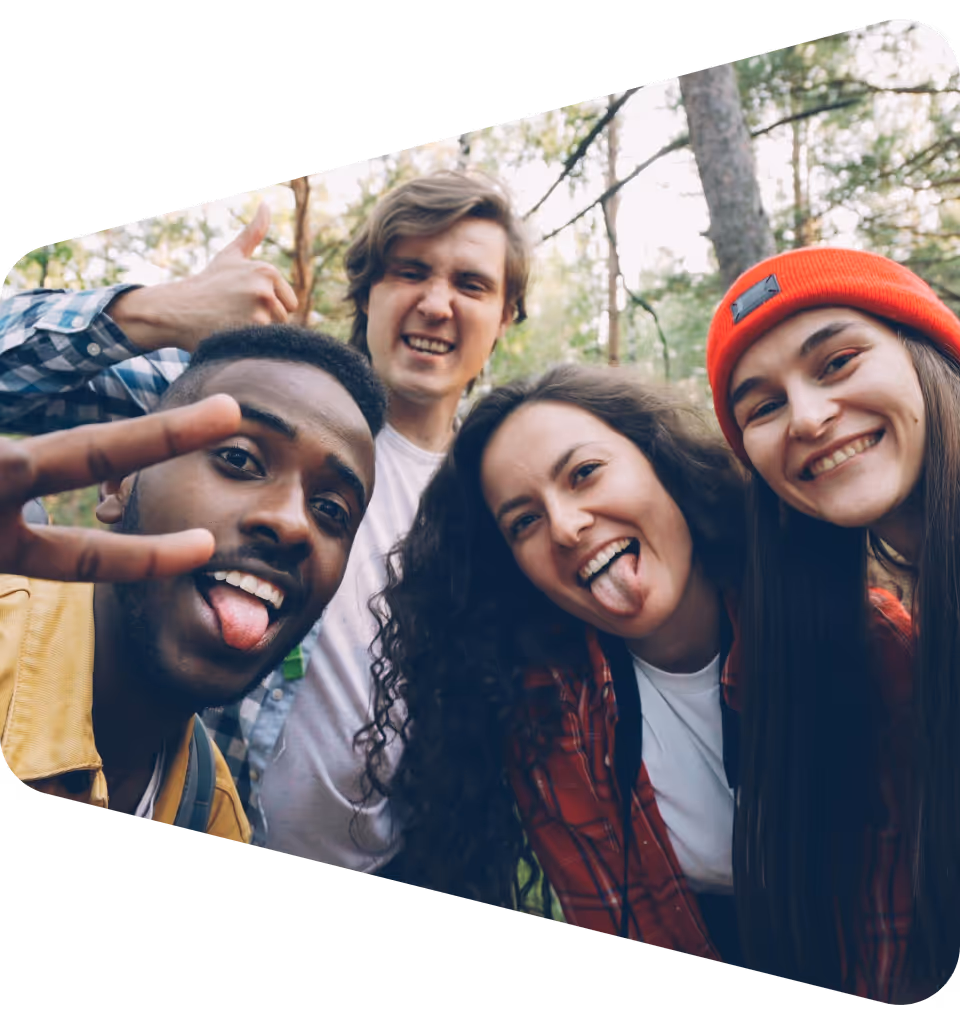 Four diverse young adults smiling and making playful expressions outdoors, symbolizing AIESEC’s mission to empower the next generation of U.S. leaders through inclusive global experiences.