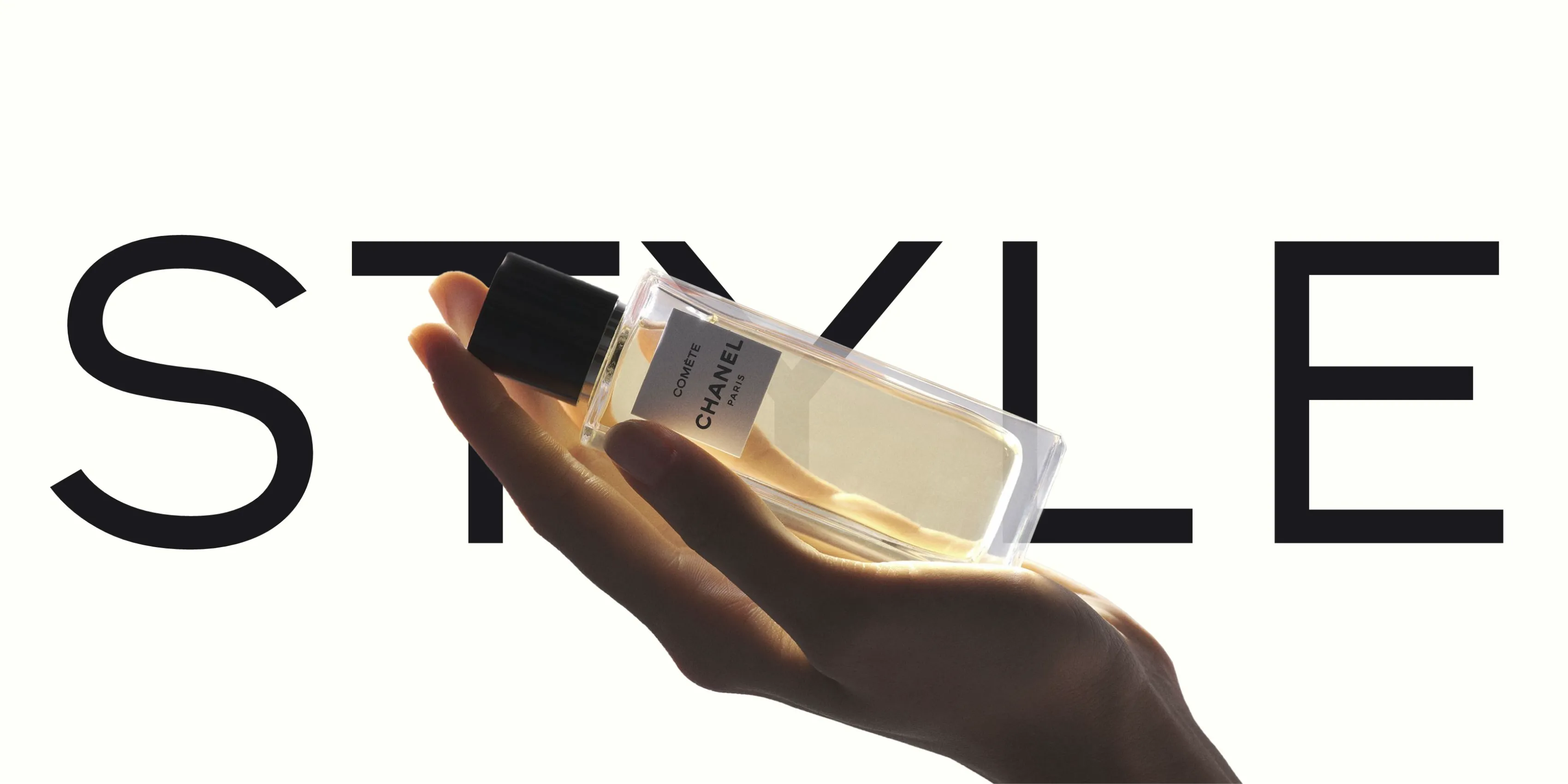 Flacon Comète Chanel tenu à la main sur fond du mot « Style », slide de la production Chanel