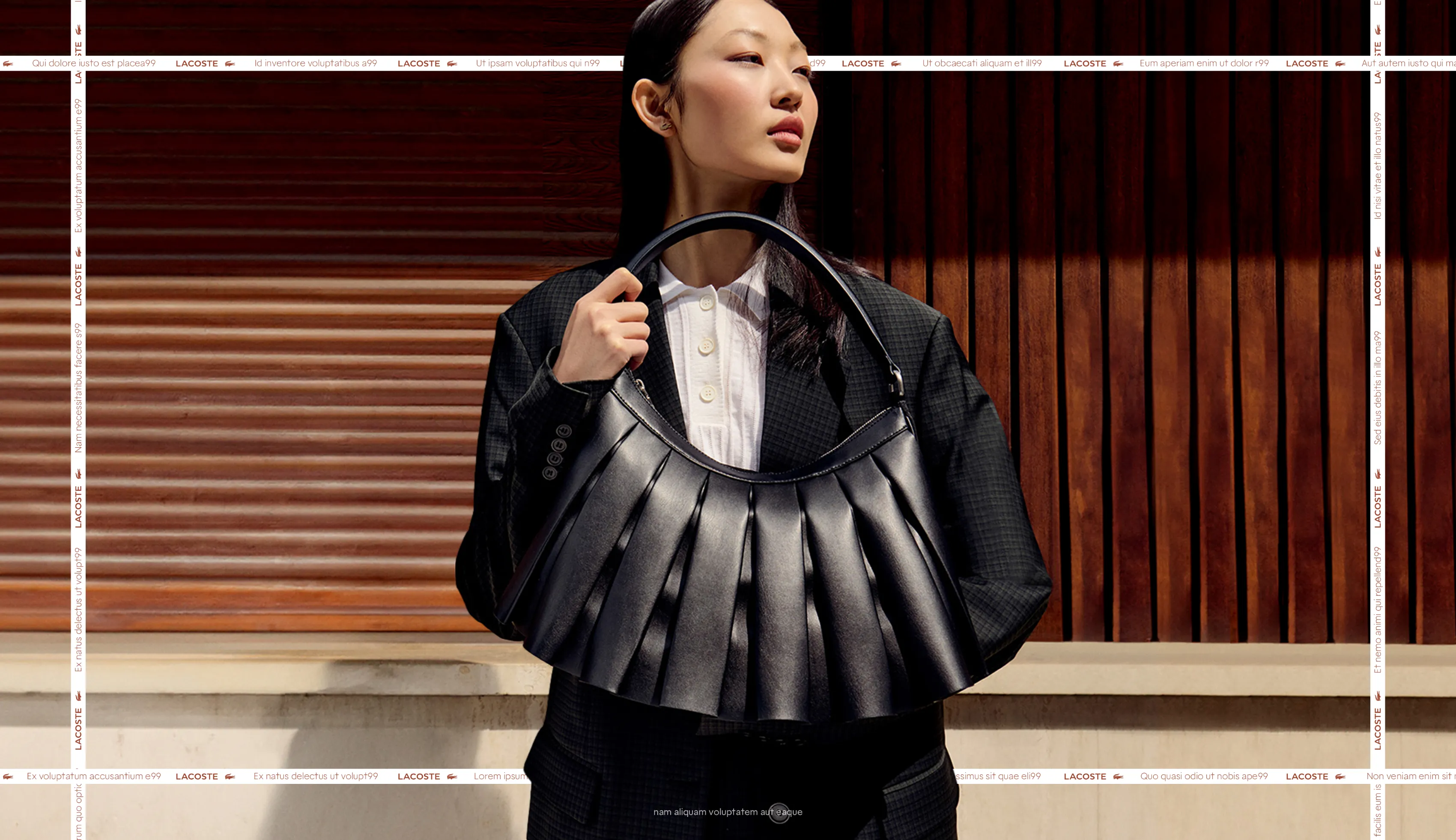Lacoste model wearing a black pleated leather handbag with a dark suit.